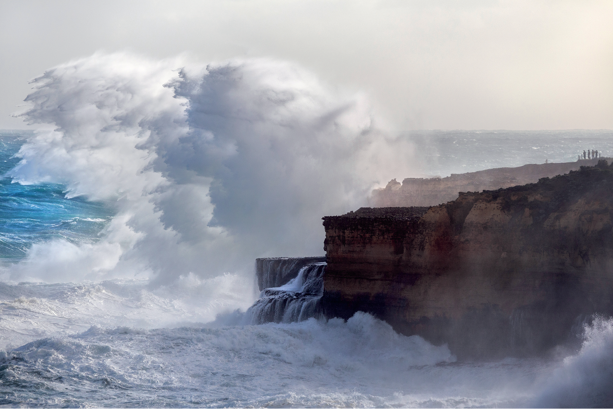 Spray from huge waves hangs many metres in the air alongside cliffs.