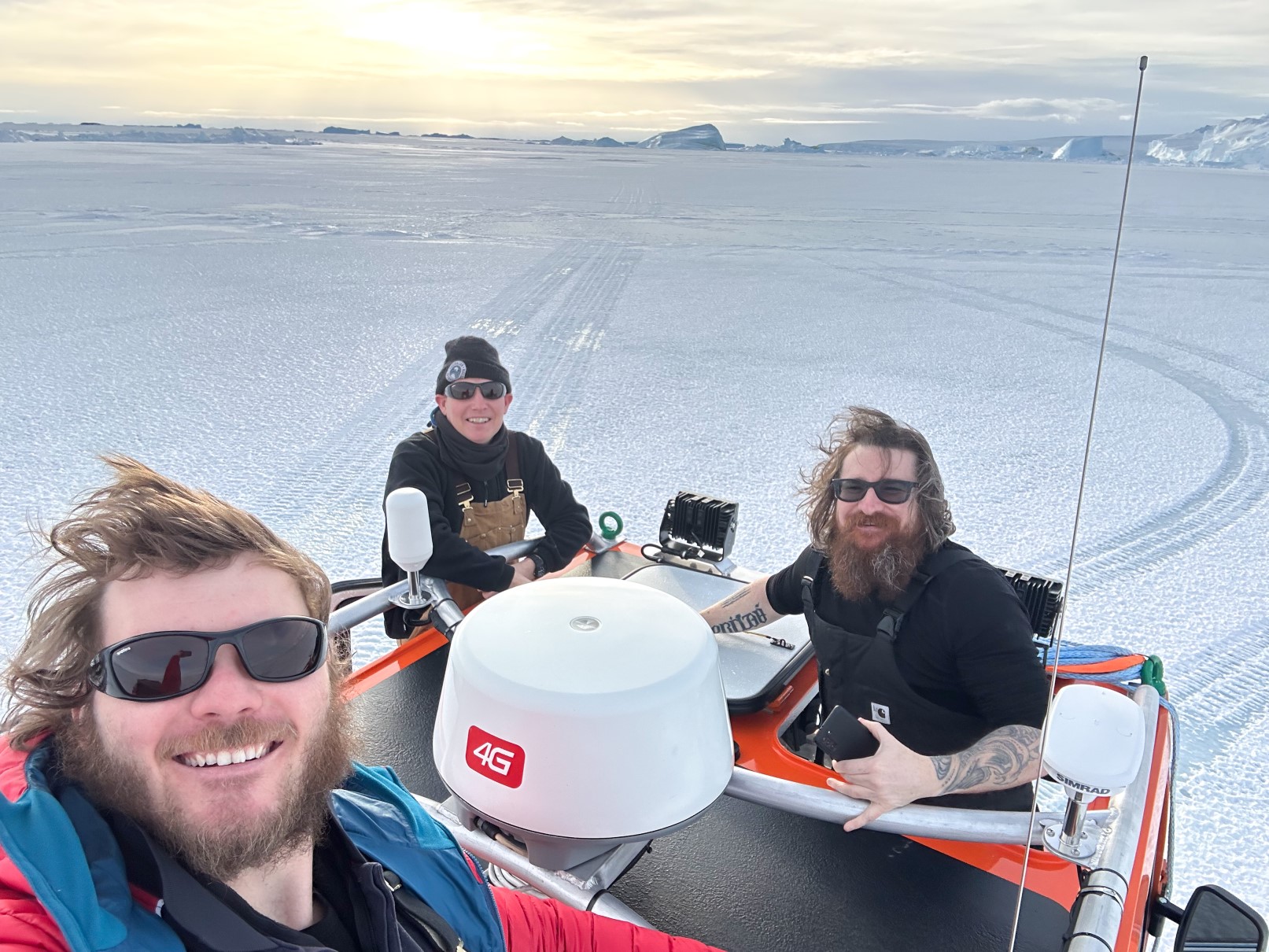 One of our technical officers, Albert, sits in a vehicle with another man and woman from his base as they take a selfie on 2 m thick sea ice.